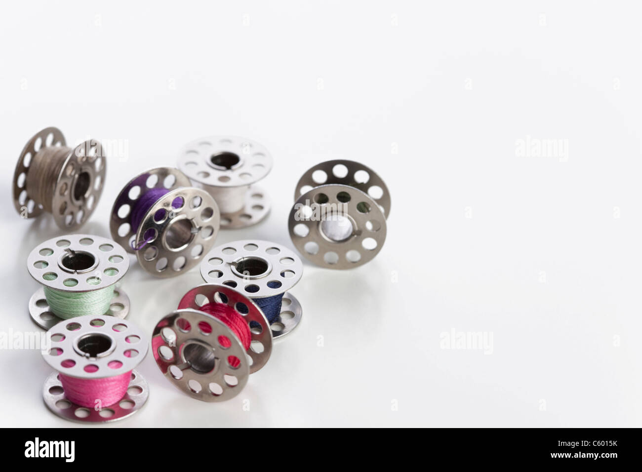 Studio shot of sewing machine bobbins of colored thread Stock Photo