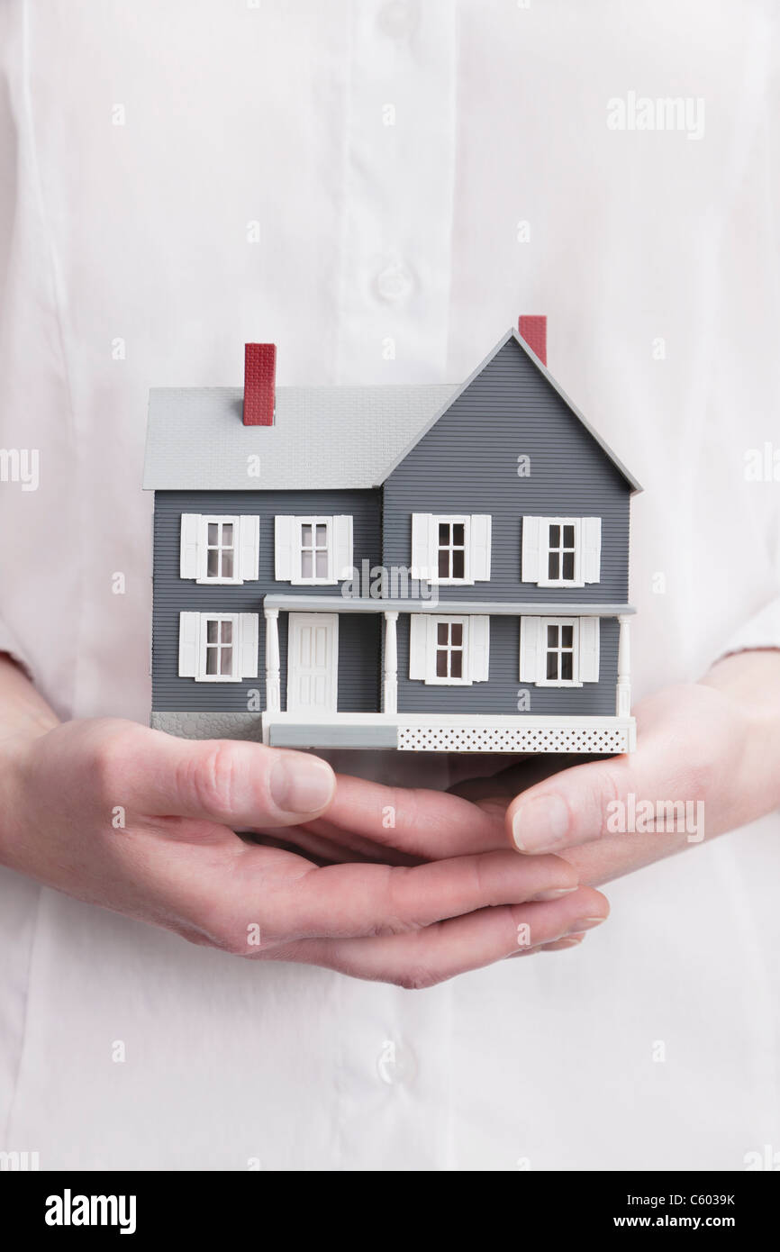 Close up of woman's hands holding model house Stock Photo - Alamy