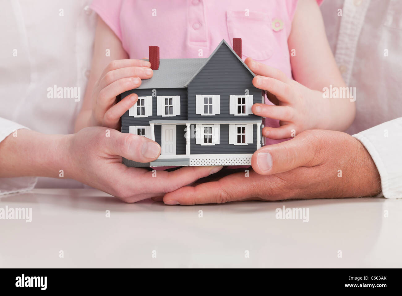 Close up of family hands holding model house Stock Photo - Alamy