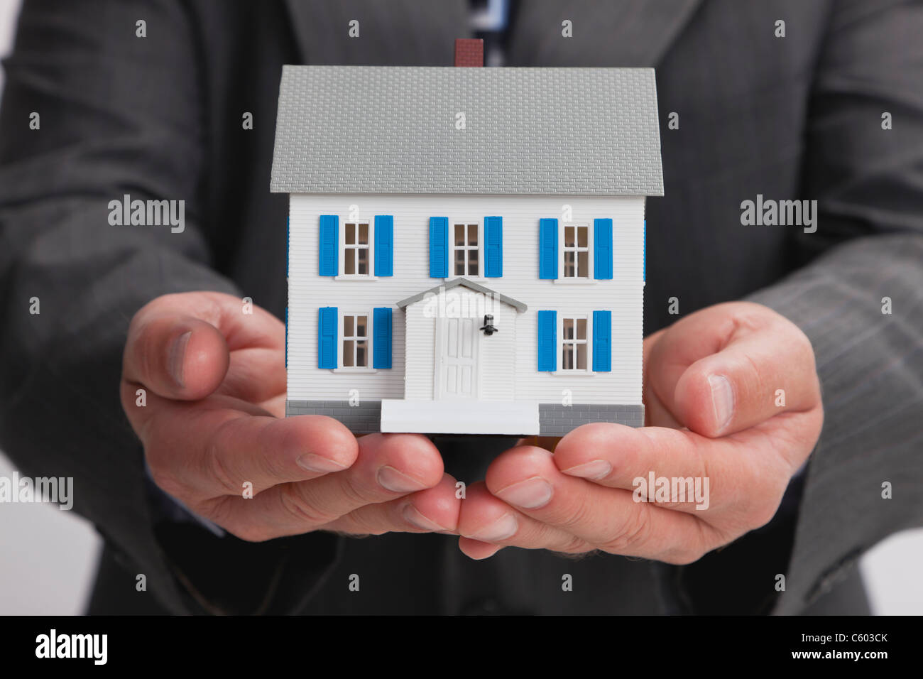 Close up of man's hands holding model house Stock Photo - Alamy