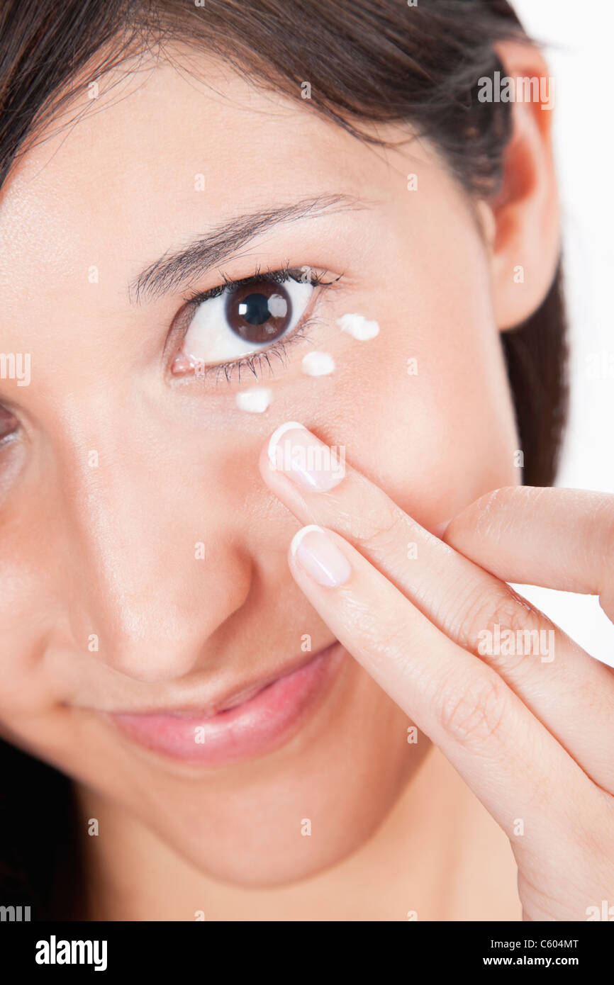 Young woman applying moisturizer under eye Stock Photo Alamy