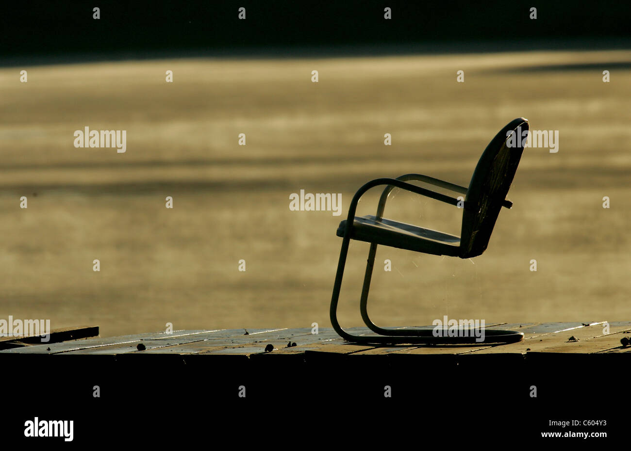 summer chair on a dock overlooking a lake Stock Photo - Alamy