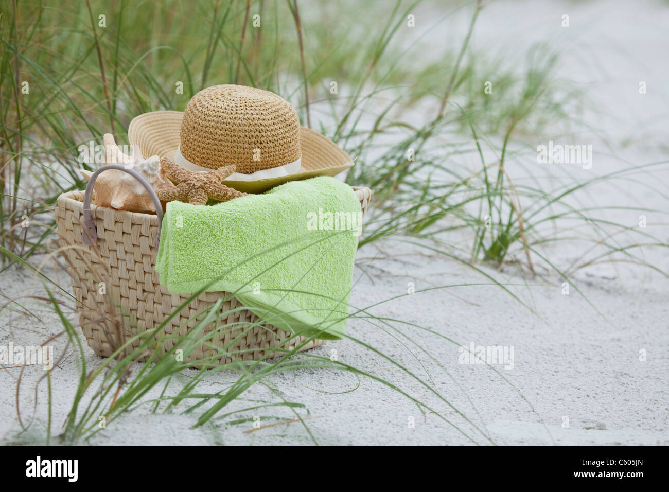 USA, Florida, St. Pete Beach, Basket with straw hat, towel and shells on beach Stock Photo