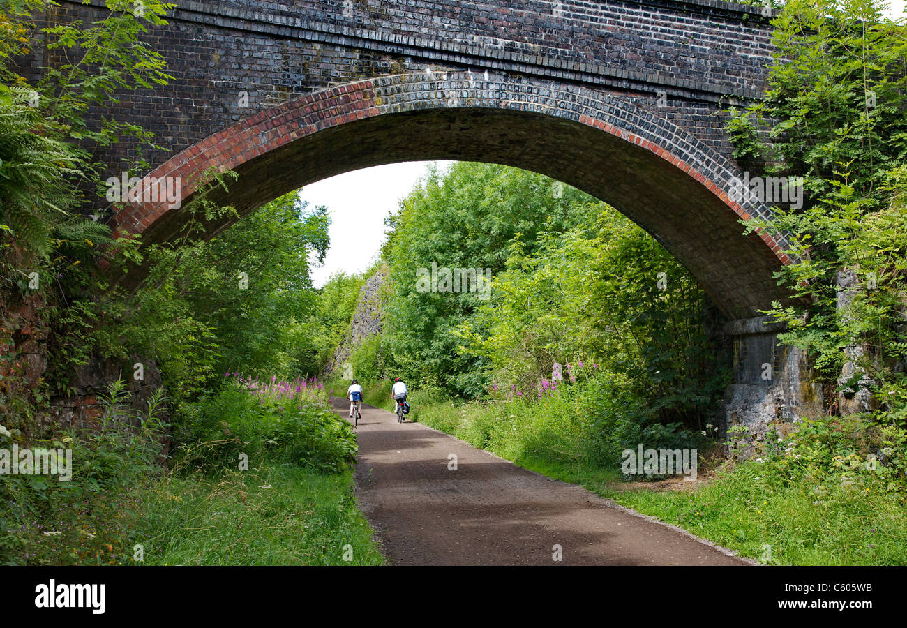 Cyclists passing under a bridge on the Monsal Trail at Litton Mill Miller's dale in the Derbyshire Peak District Stock Photo