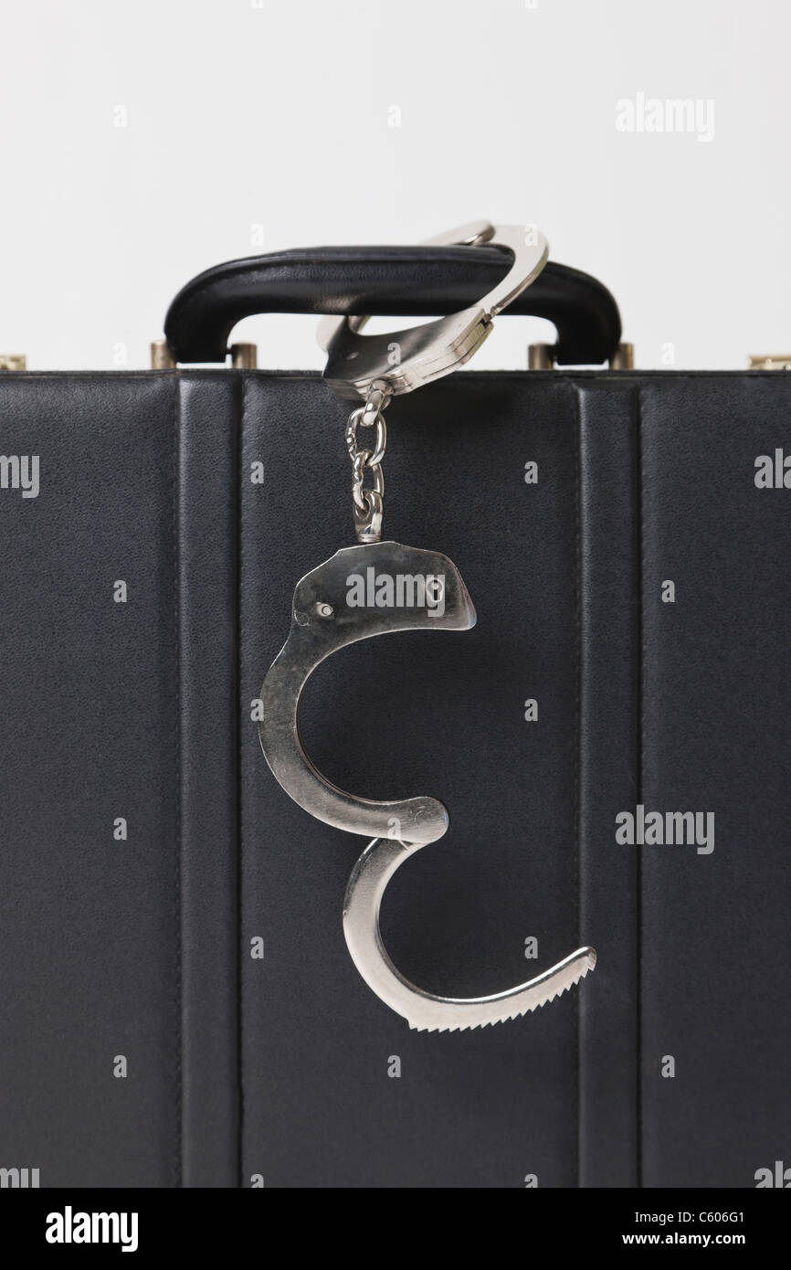Briefcase with handcuffs locked to handle, close-up Stock Photo