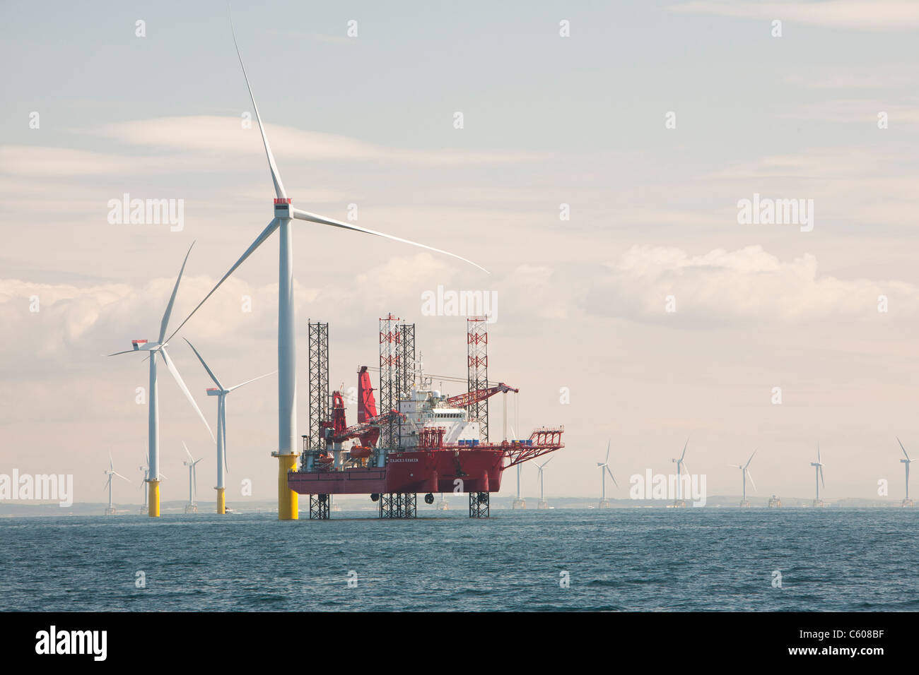 A jack up barge constructing wind turbines on the Walney offshore wind farm, Cumbria, UK. Stock Photo