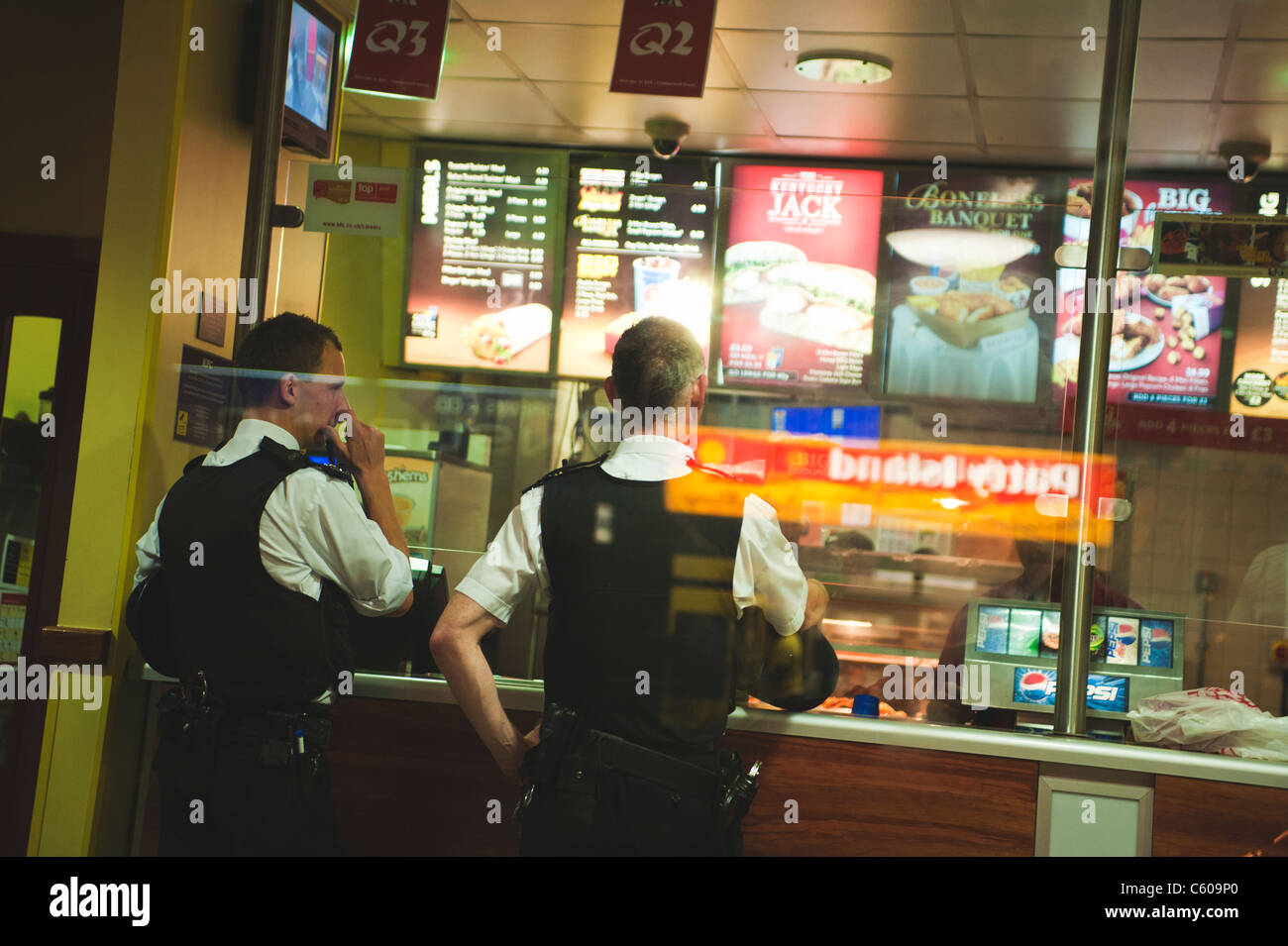 Police taking a break in the KFC during the London Riots. Stock Photo