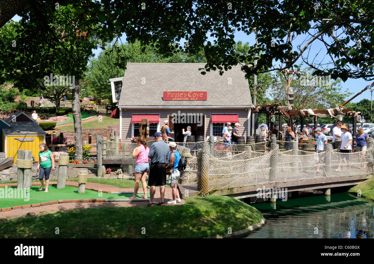 Tourists playing mini-golf on a sunny clear summer day at Pirates Cove in  Yarmouth, Cape Cod Massachusetts USA Stock Photo
