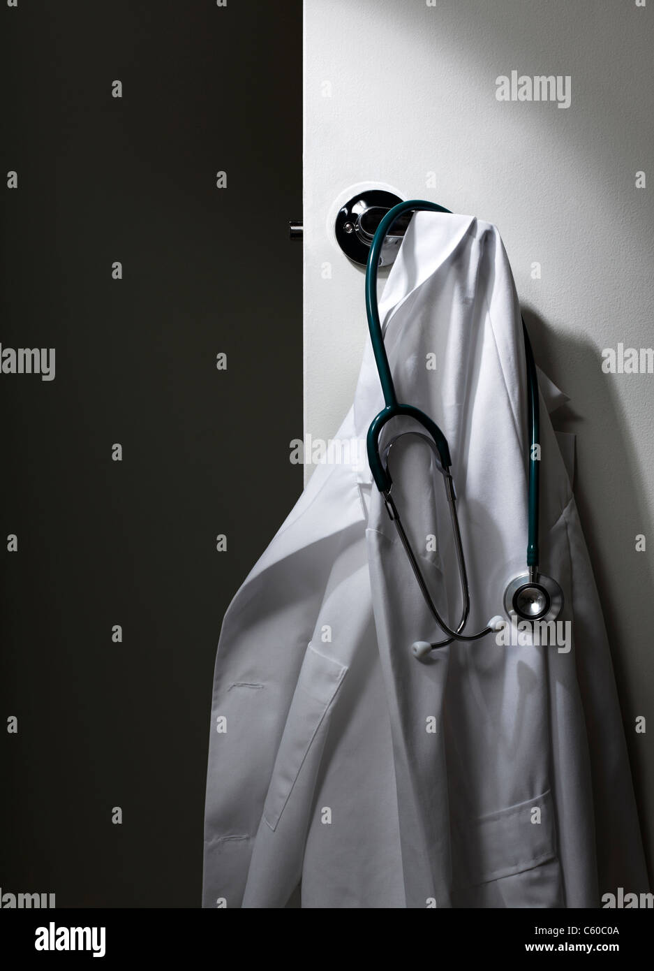 Doctors Lab Coat hanging on door Stock Photo