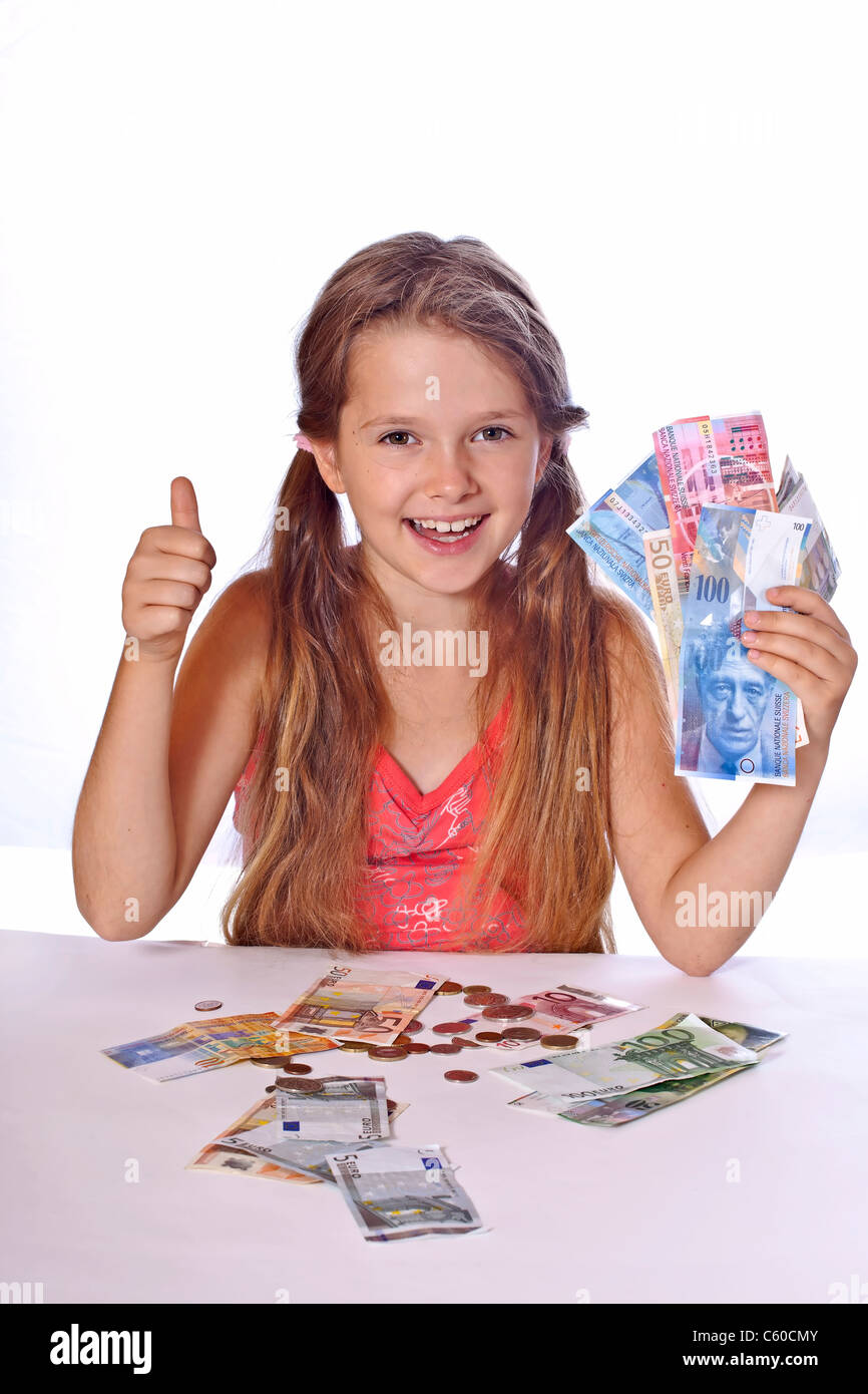 eight year old girl counts her money Stock Photo