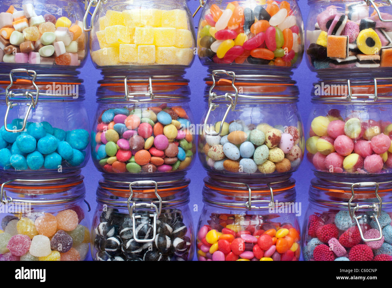 Colourful childrens sweets in kilner jars. Liquorice allsorts, Smarties, pineapple cubes, humbugs, bonbons, dolly mixtures, jelly beans and mini eggs Stock Photo