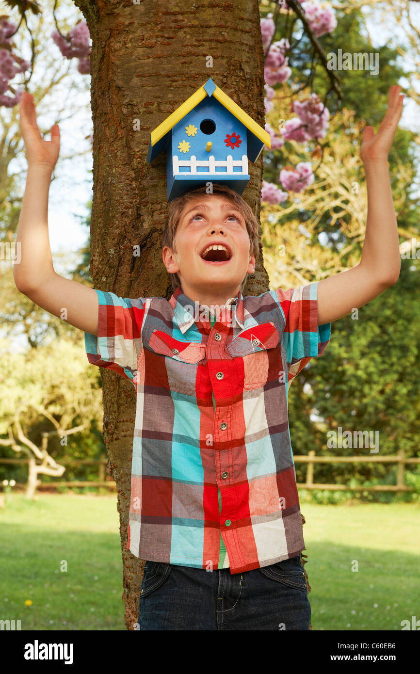 Boy holding birdhouse on his head Stock Photo