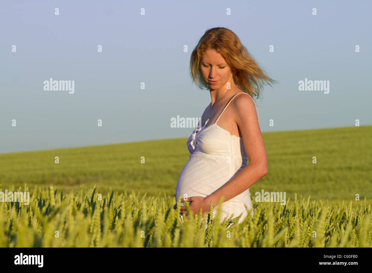 pregnant woman in white dress relaxing outdoors Stock Photo - Alamy