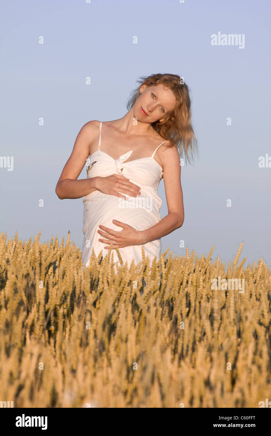 pregnant woman in white dress relaxing outdoors Stock Photo - Alamy