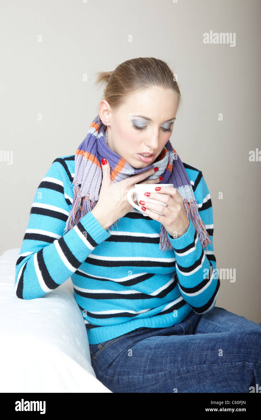 Sick woman drinking hot tea. Indoors photo Stock Photo - Alamy