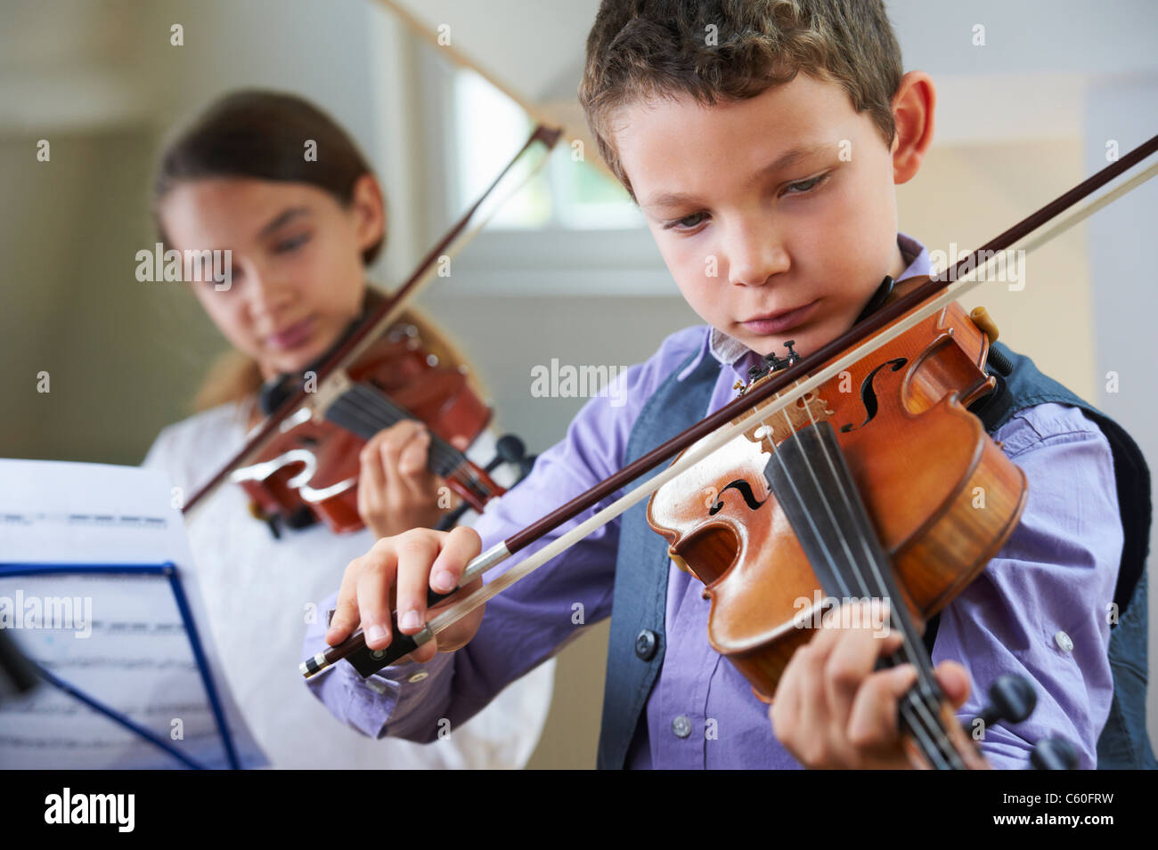Serious children playing violin Stock Photo