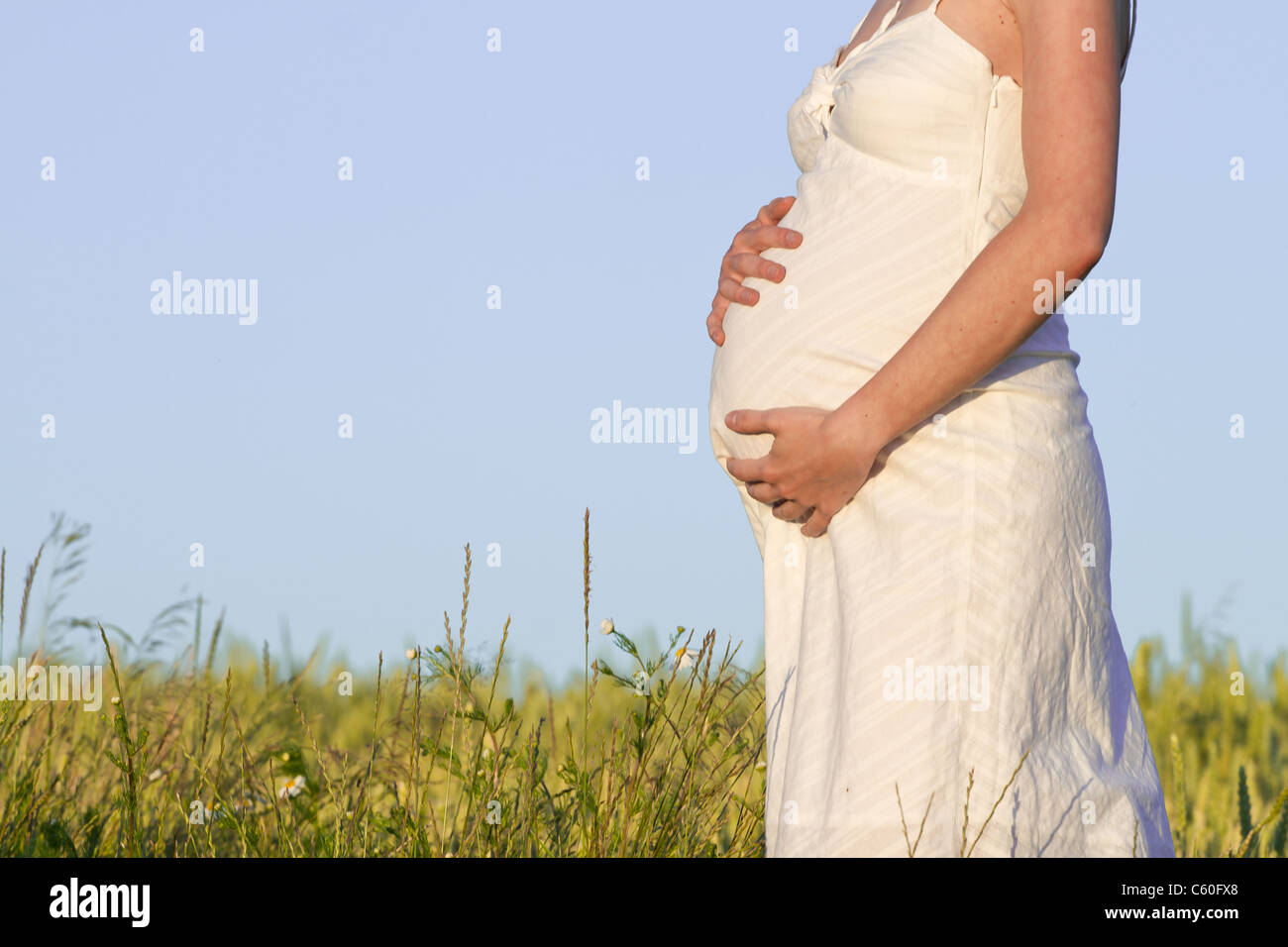 pregnant woman in white dress relaxing outdoors Stock Photo - Alamy