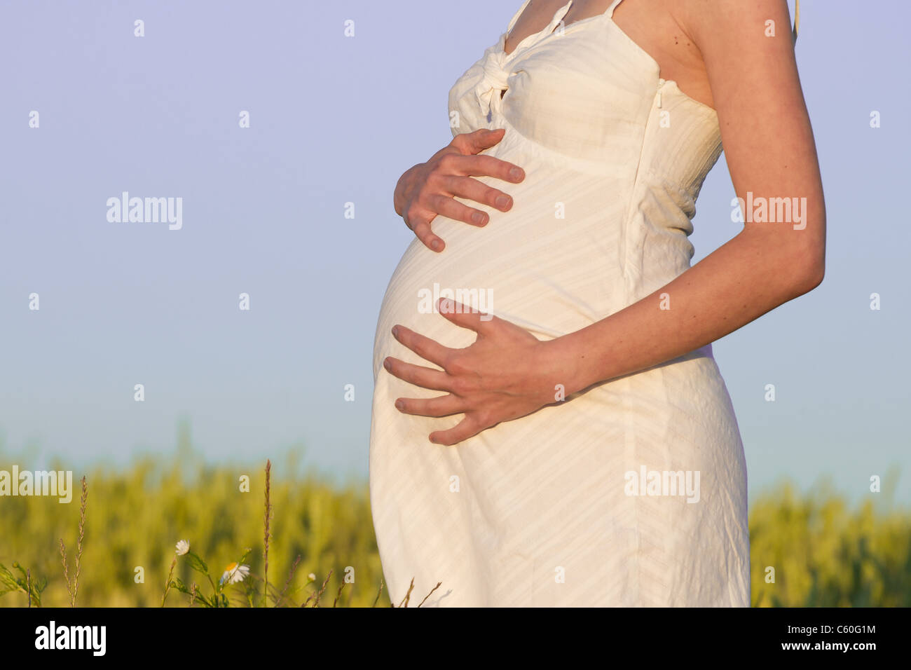 pregnant woman in white dress relaxing outdoors Stock Photo - Alamy