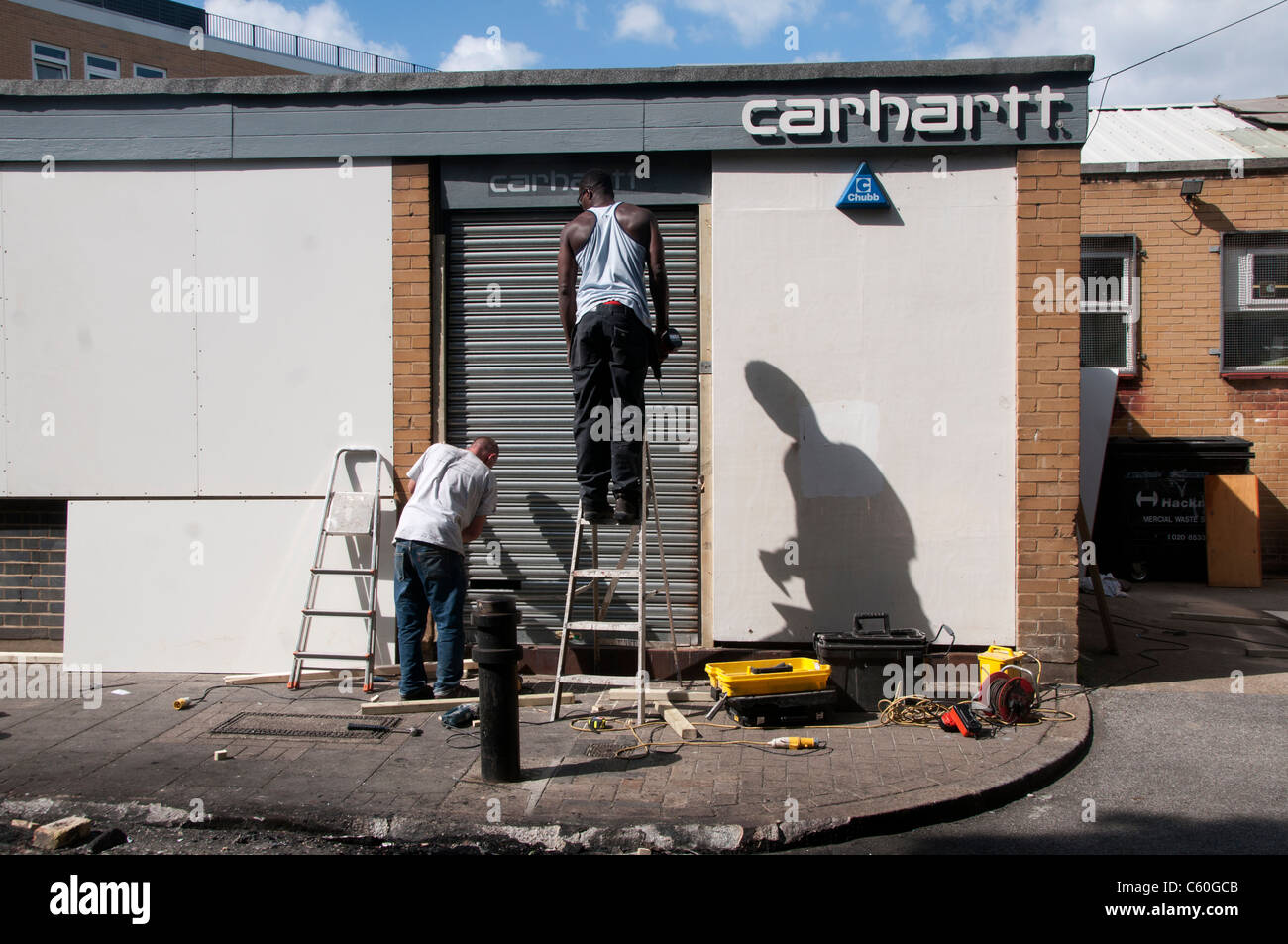 Hackney after the riot. Boarding up Carhartt warehouse after it was looted. Stock Photo