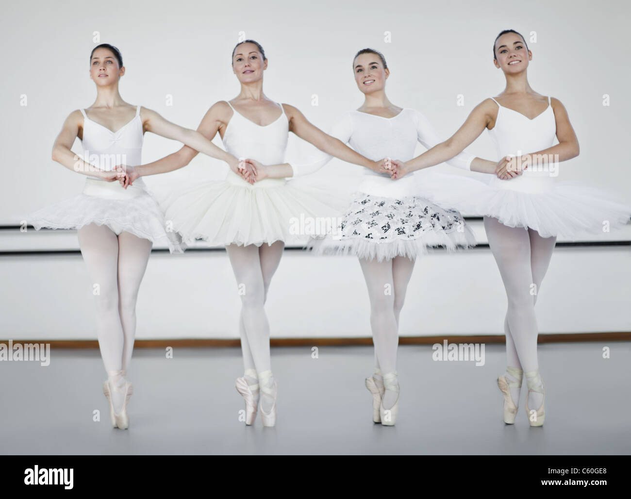 Ballet dancers holding hands in studio Stock Photo