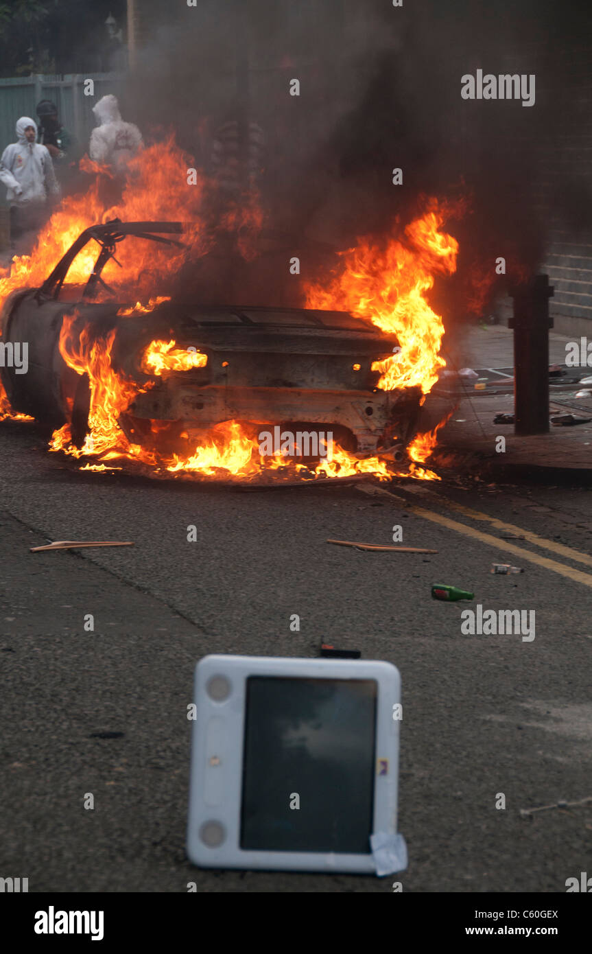 Burning car in front of Carhartt  Warehouse which was looted during the riot.An looted apple mac computer lies in the street. Stock Photo