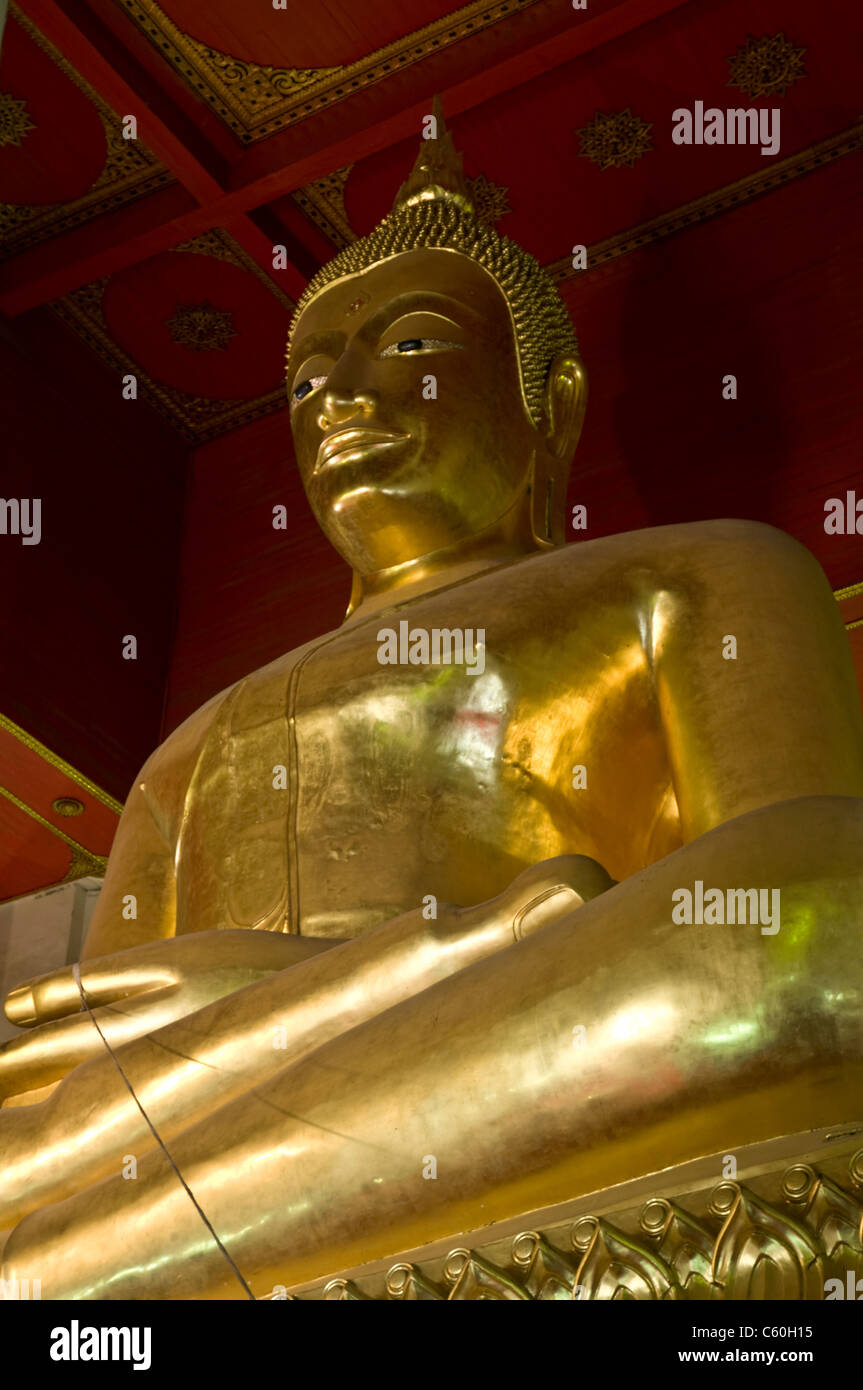 Gold Buddha statue festive temple red front view Stock Photo