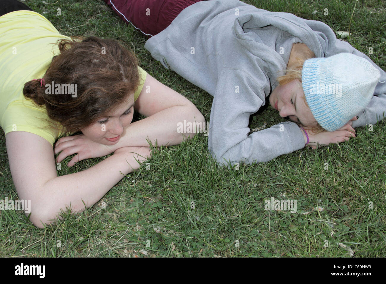 Girls laying in grass at park Stock Photo