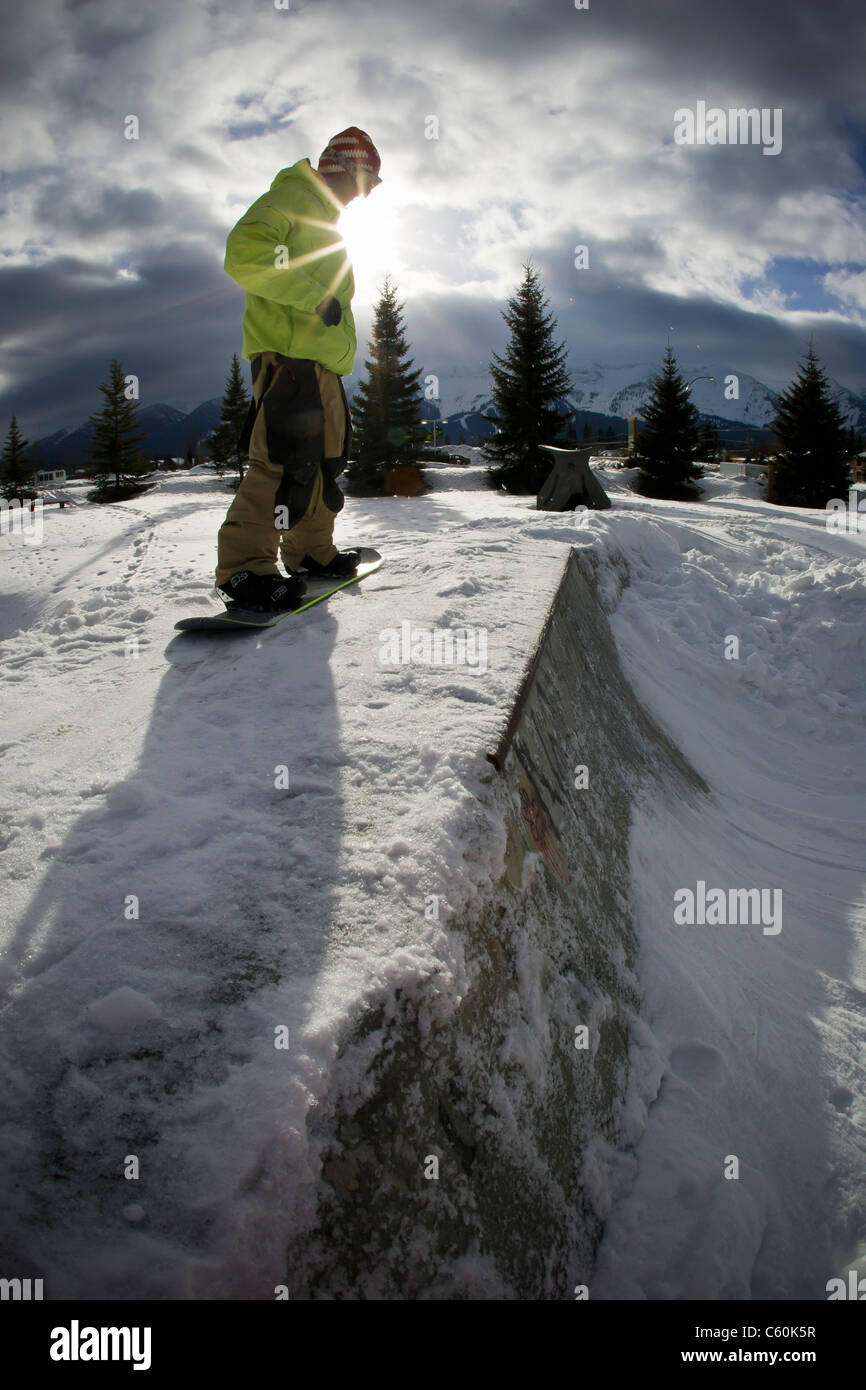 Snowboarder standing on half-pipe Stock Photo