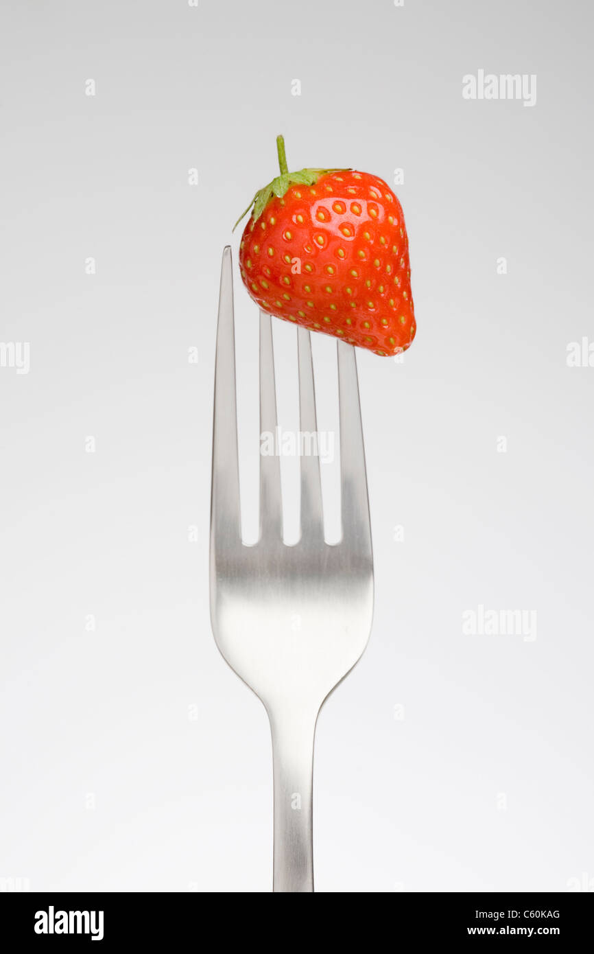 Close up of strawberry on fork Stock Photo