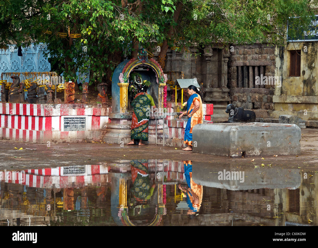 Two women at small shrine within Sri Meenakshi Temple Madurai Tamil Nadu South India Stock Photo
