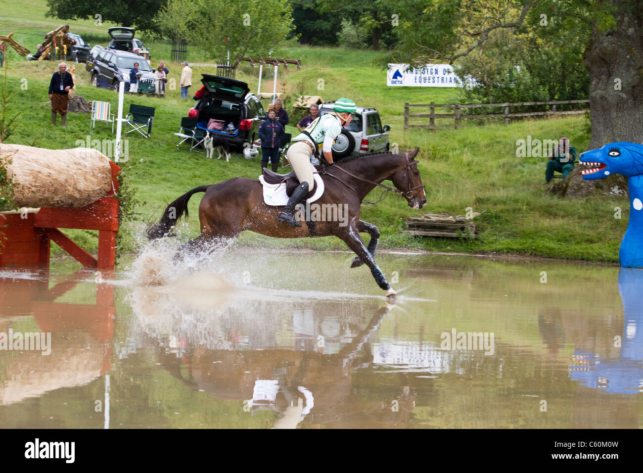 Horse and rider in the water on the cross-country at the British Festival of eventing at Gatcombe Park in Gloucestershire Stock Photo