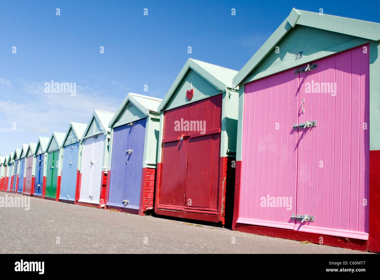 East Sussex , Hove actually , colorful or colourful beach huts on the promenade or seafront Stock Photo