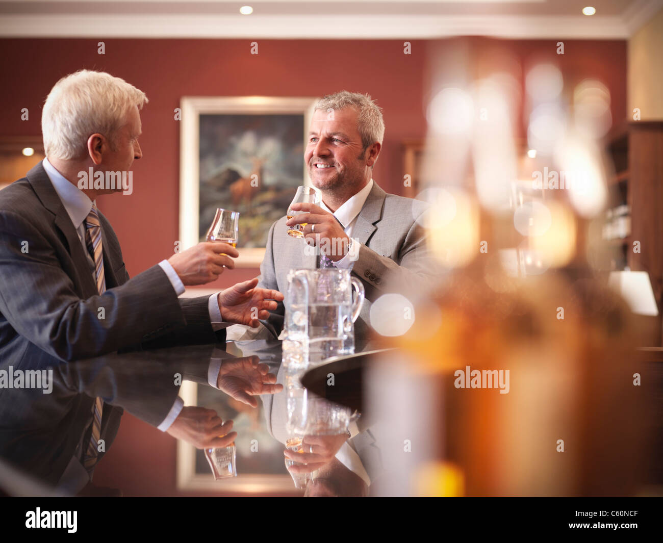 Businessmen drinking together in bar Stock Photo
