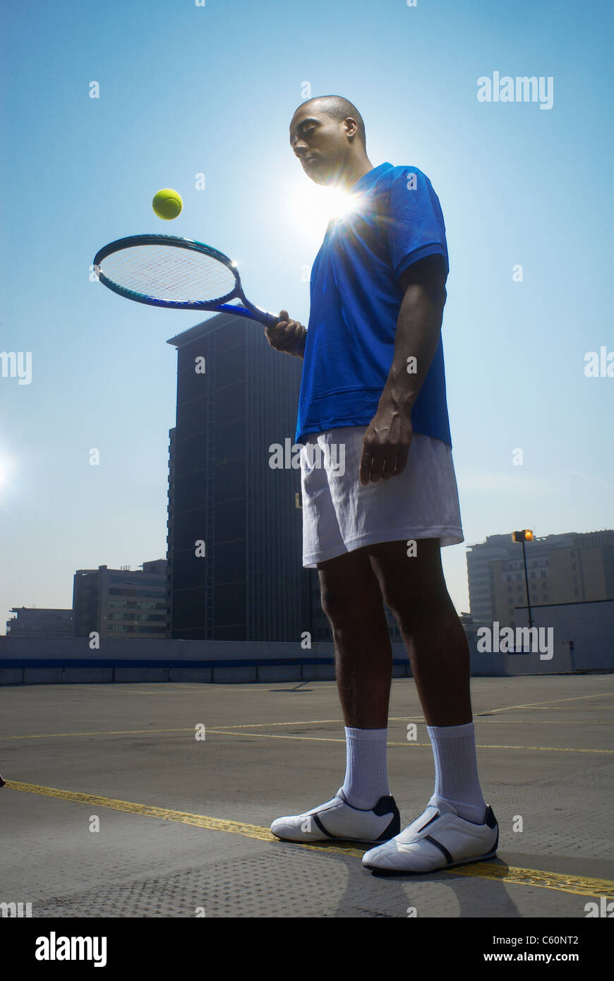 Tennis player on rooftop court Stock Photo