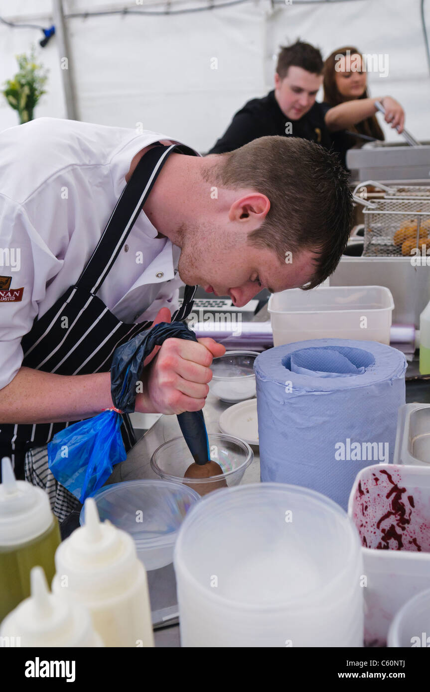 Chef pipes a chocolate mousse in a marquee restaurant Stock Photo