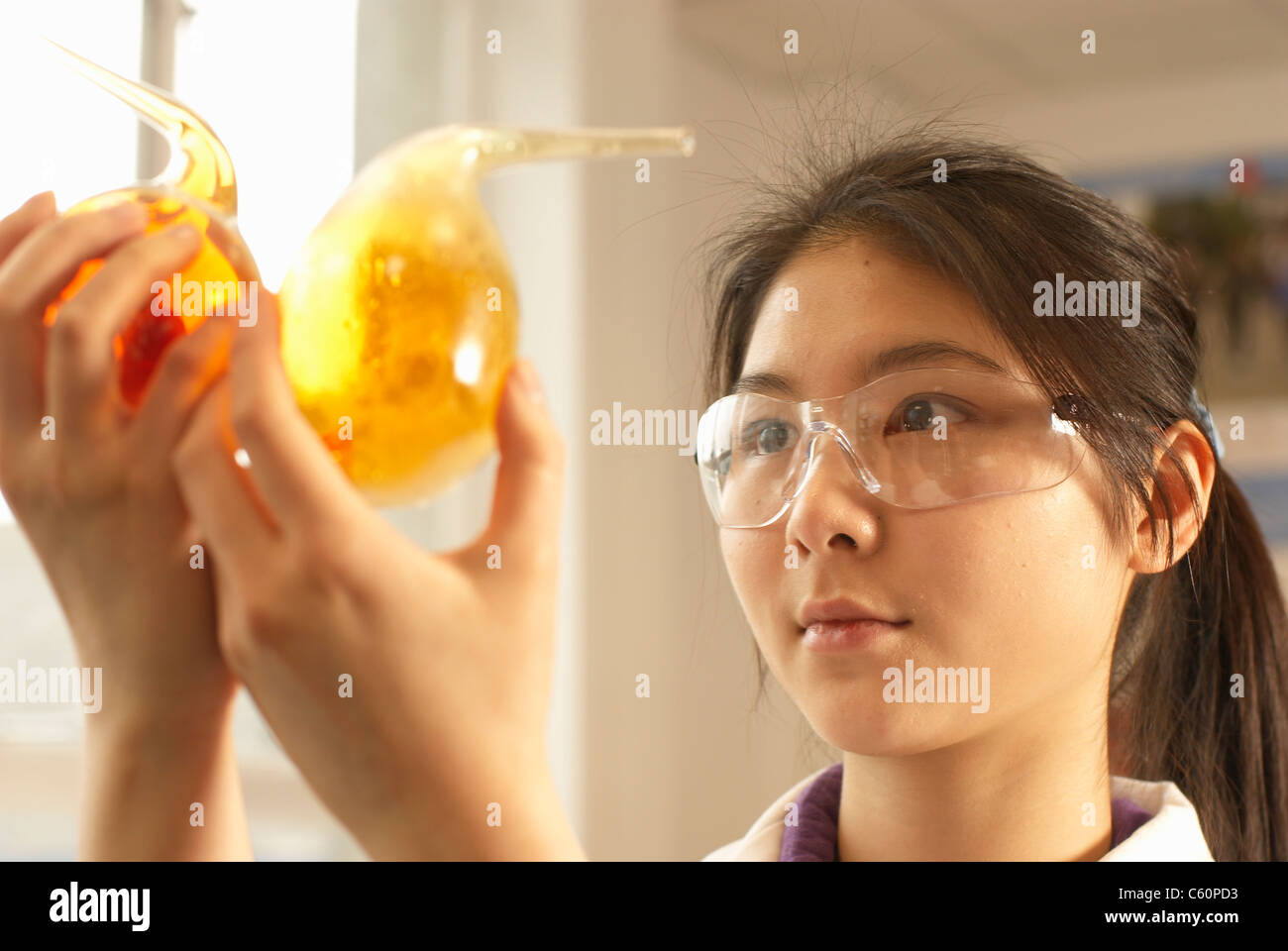 Scientist examining liquid in beakers Stock Photo