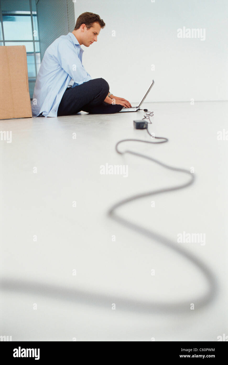 Businessman using laptop on floor Stock Photo Alamy