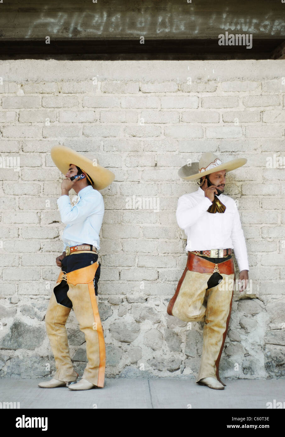 'The Calling' - Mexican cowboys talk on cell phones outside the bullring in Ajijic, Jalisco, Mexico. Stock Photo