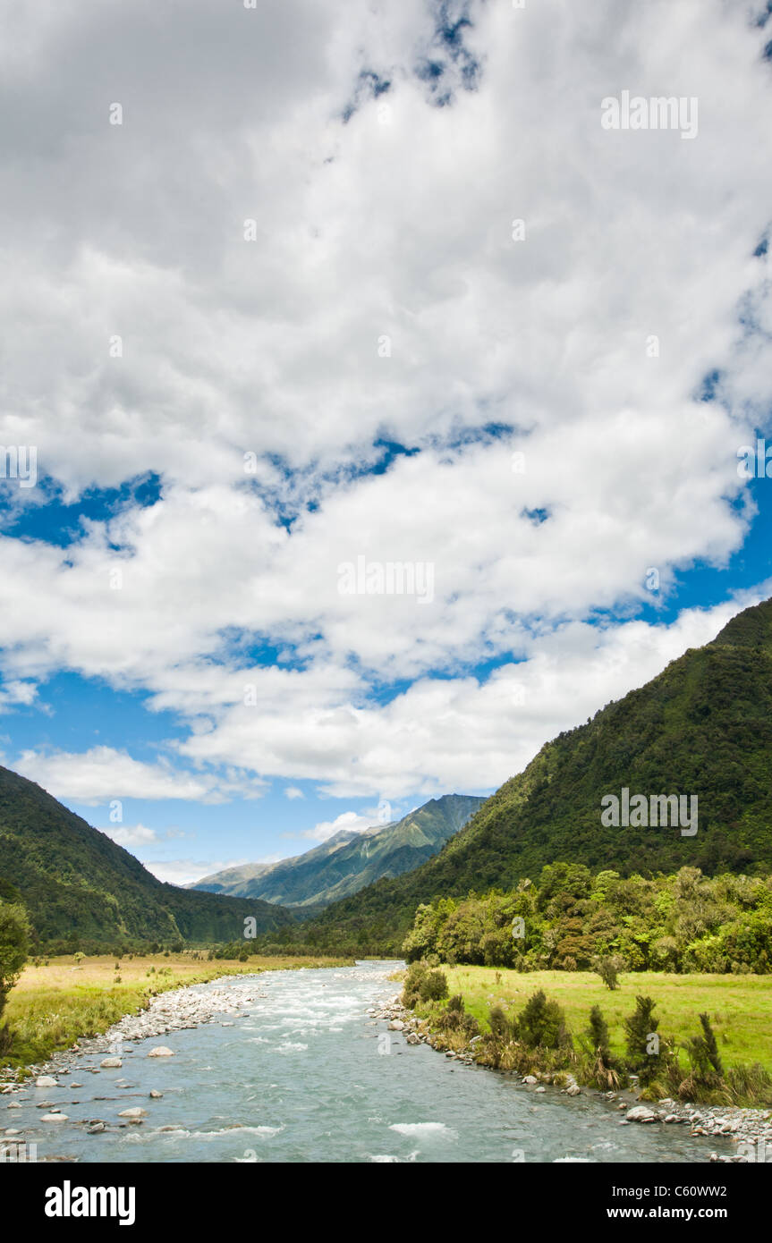 river flowing through a valley with massive cloudy sky Stock Photo - Alamy