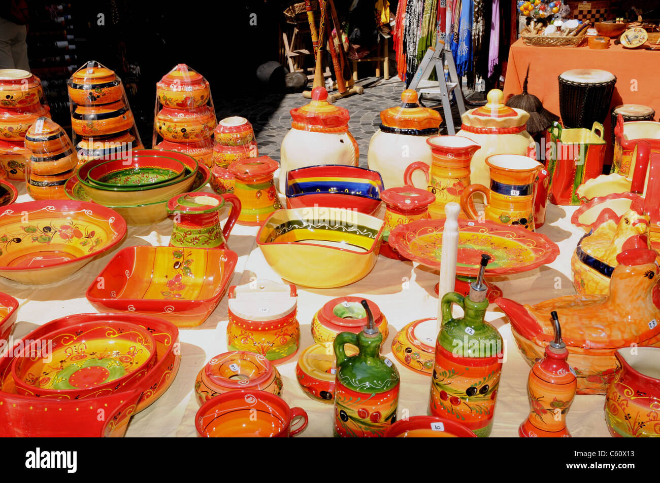 Brightly coloured traditional pottery for sale on a stall in Anduze, Gard, France. Stock Photo