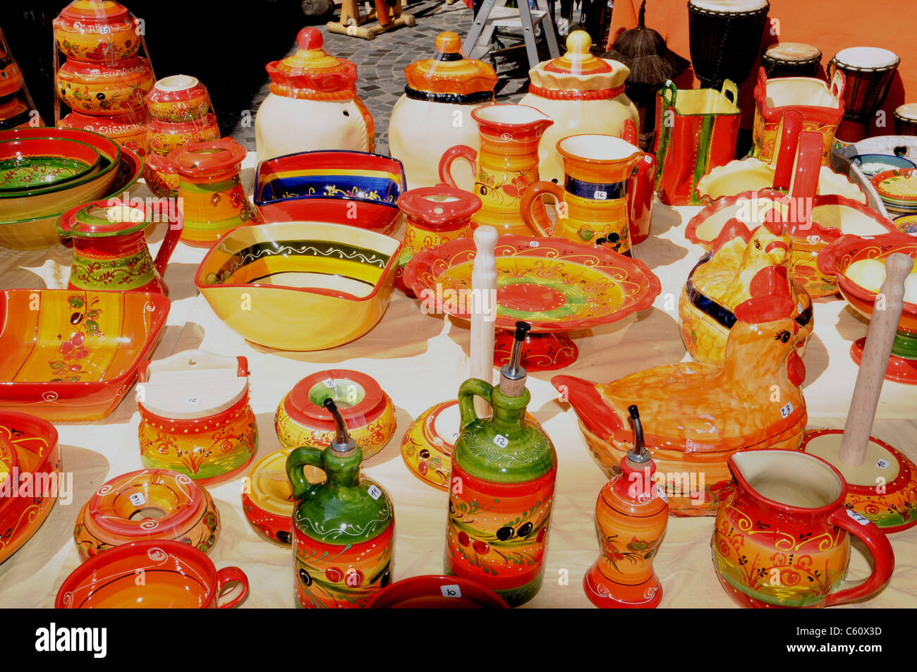 Brightly coloured traditional pottery for sale on a stall in Anduze, Gard, France. Stock Photo