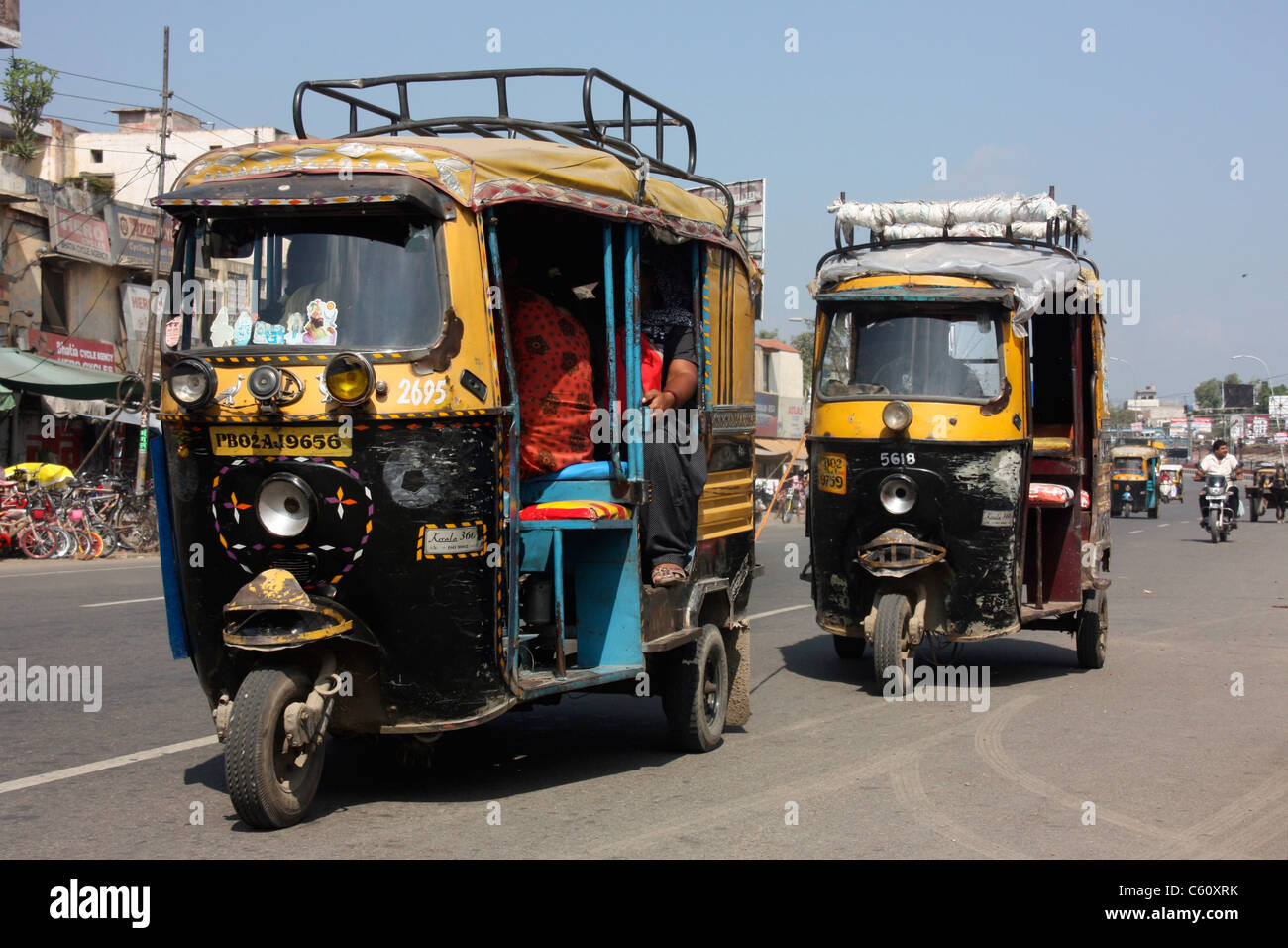 Three wheeler auto rickshaws race through city streets of Amritsar Punjab northern India Stock Photo