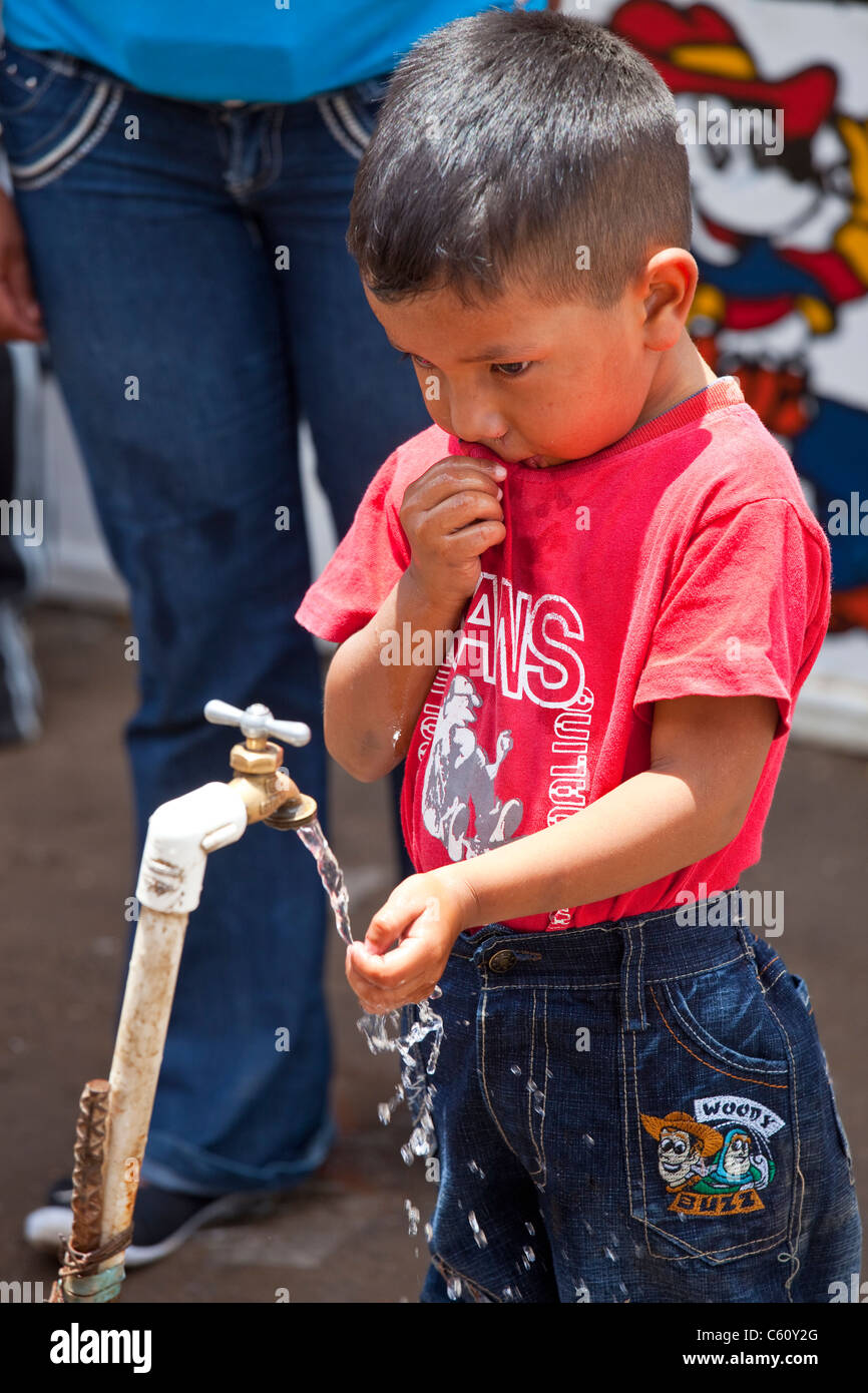 Boy at a public water faucet, Antigua, Guatemala Stock Photo