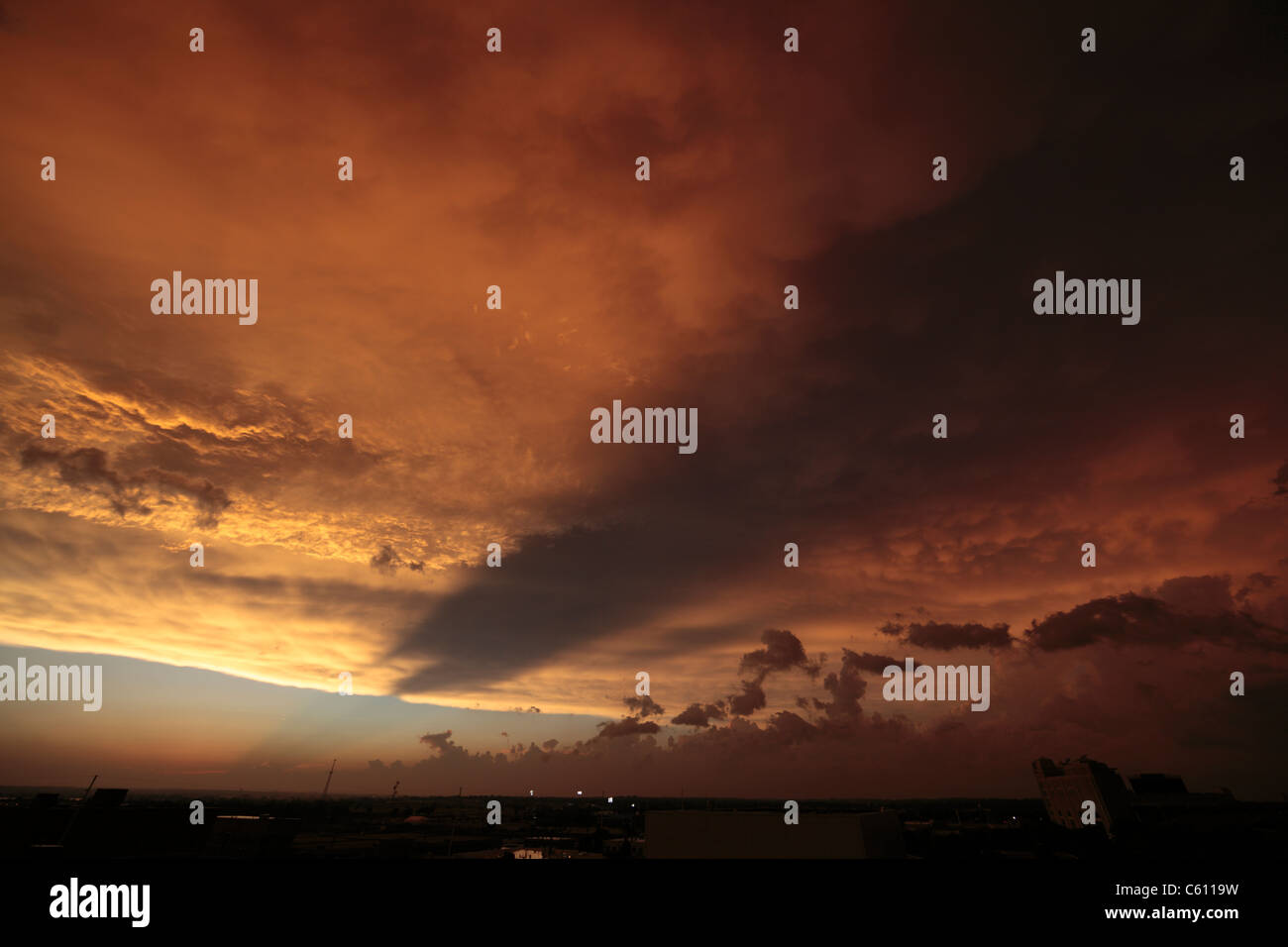 Distinct crepuscular rays over scud and mammatus cloud formations at sunset. Stock Photo