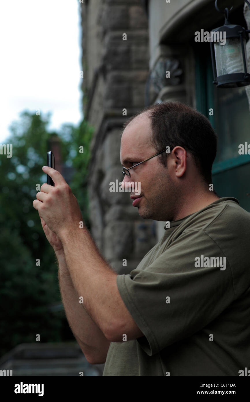 Man operating smartphone to take picture. Stock Photo