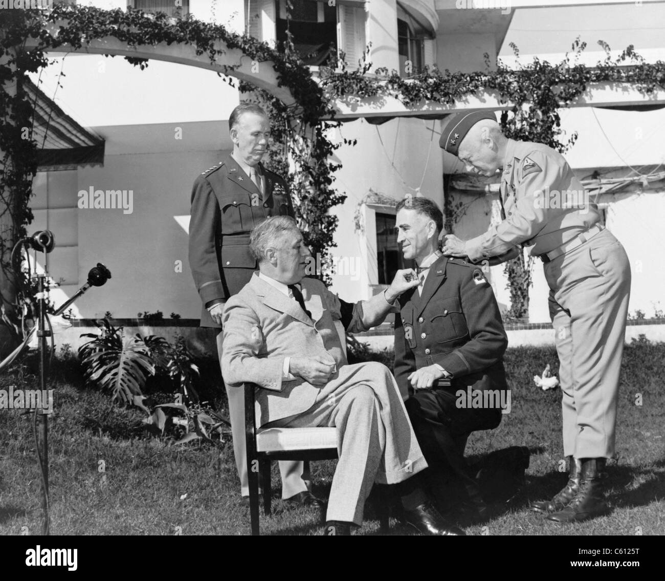 President Roosevelt with Major General George Patton, pinning the Congressional Medal of Honor upon Brig. General William H. Wilbur, as General George Marshall looks on. Wilbur was awarded the medal for his actions during the Allied invasion of North Africa. January 1943. Stock Photo