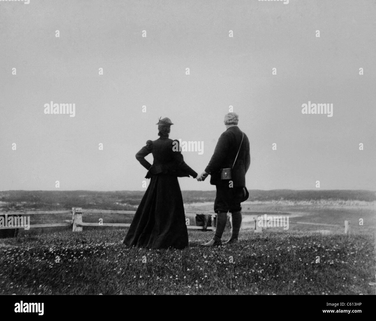 Alexander Graham Bell and Mabel Hubbard Bell hold hands and look toward the sea from Sable Island, Canada in 1898. Mable lost her hearing from scarlet fever at age five, and met Bell when she was his 15 year old student. They married five years later. Stock Photo