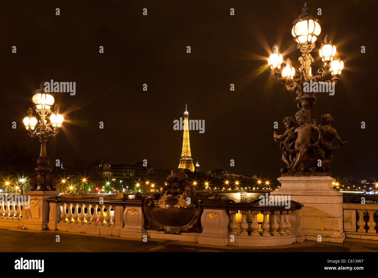 Night illumination on the bridge of Alexander III and Eiffel Tower in the background. Paris. France. Stock Photo