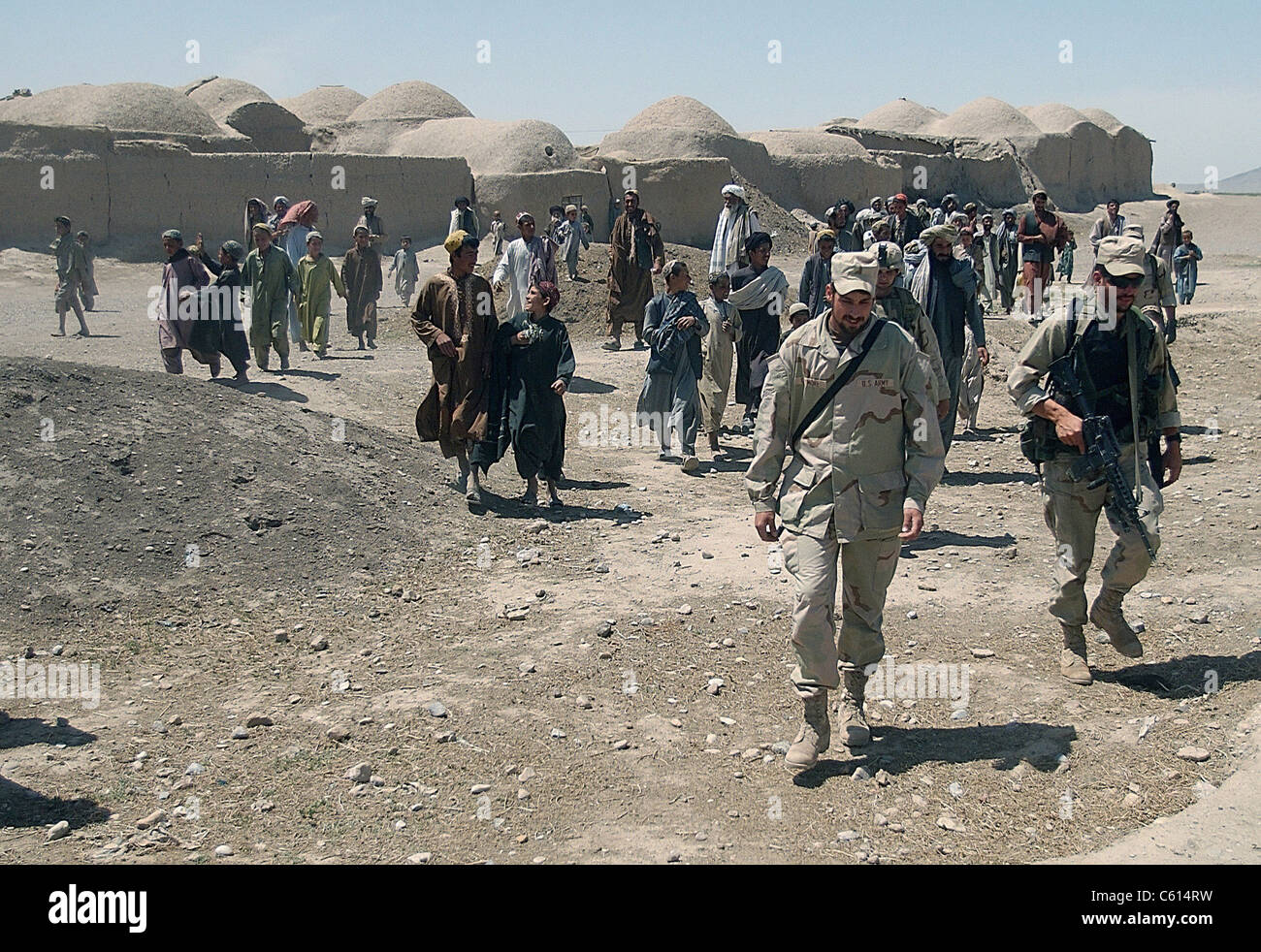 Villagers from Nojoy outside Kandahar International Airport follow the members of the U.S. Army's Tactical Psychological Operations Team as they leave after meeting with the village elders. April 16 2002., Photo by:Everett Collection(BSLOC 2011 6 91) Stock Photo