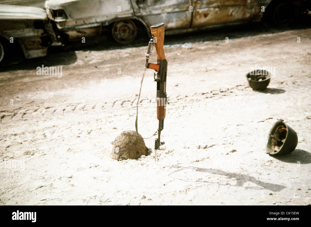 Discarded Iraqi helmets scattered around a Kalashnikov assault rifle near vehicles destroyed by Coalition forces during Operation Desert Storm. Mar. 1 1991 (BSLOC 2011 12 8) Stock Photo